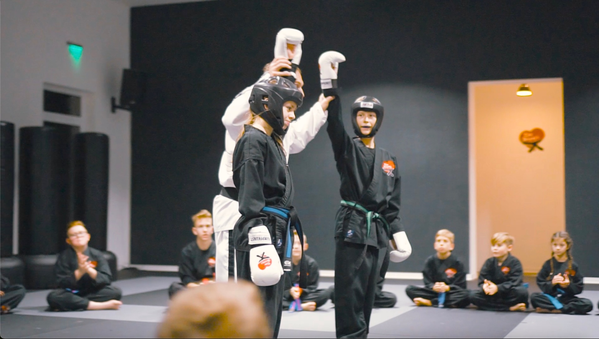 Instructor and child high-fiving in the dojo